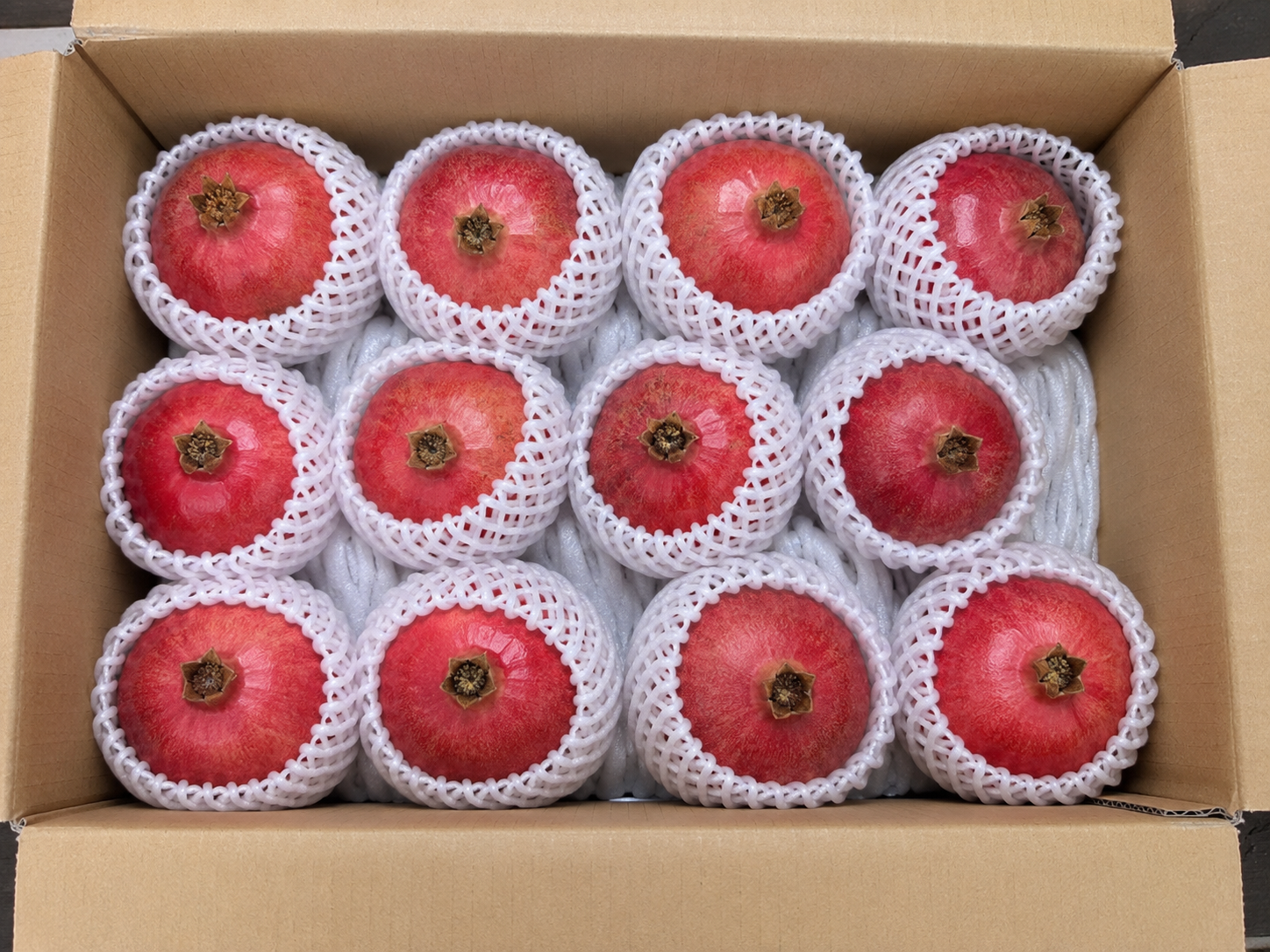 Egyptian pomegranates in foam net sleeves packed in an export carton