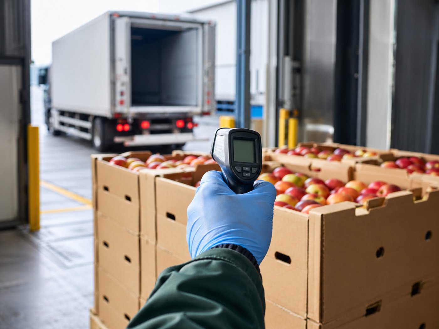 Infrared thermometer checking carton temperature at the dock during an arrival inspection of a part-load